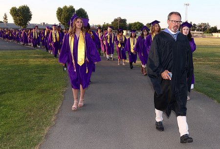 Principal Rodney Brumit leads Lemoore High School's latest graduates into Tiger Stadium.